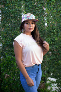 Person posing in front of any ivy wall wearing a Peach colored Aloha Shapes® Womens Muscle Tee