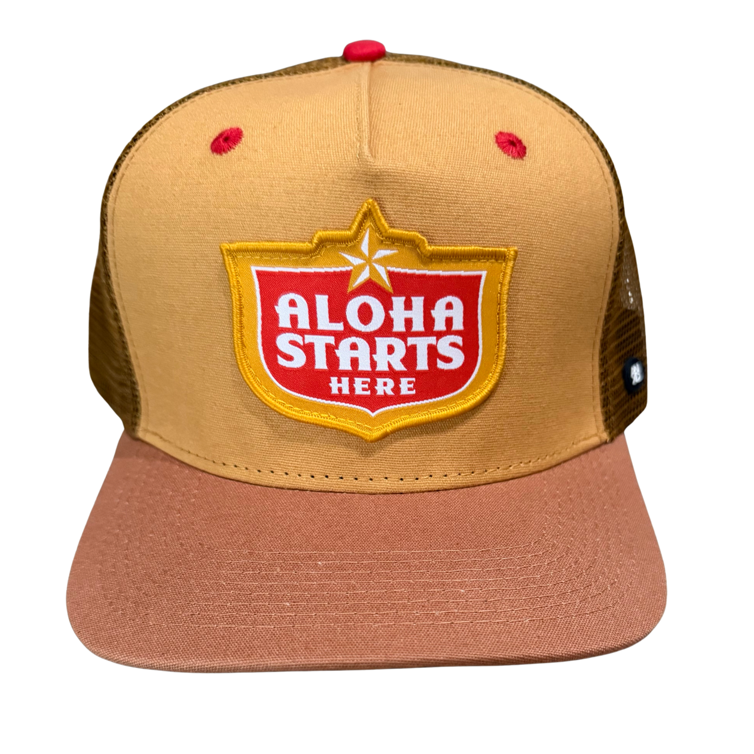 A tan and dusty rose trucker hat with a brown mesh back, featuring a red and yellow 'ALOHA STARTS HERE' patch on the front.