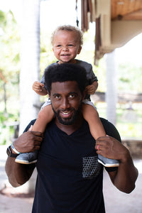 Father with son on his shoulders. Father is wearing Repeat Shapes pocket tee in black