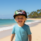 Child wearing Aloha Nights snapback backwards on beach