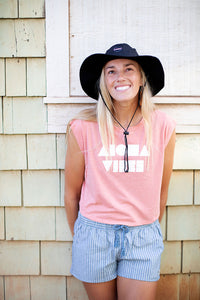 Girl smiling leaning against a wall wearing a Black Aloha Surf shapes boonie hat with chinstrap