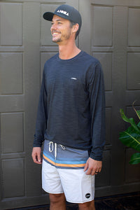 Man wearing boardshorst and long sleeve Aloha Surf Shapes loose fit sun shirt