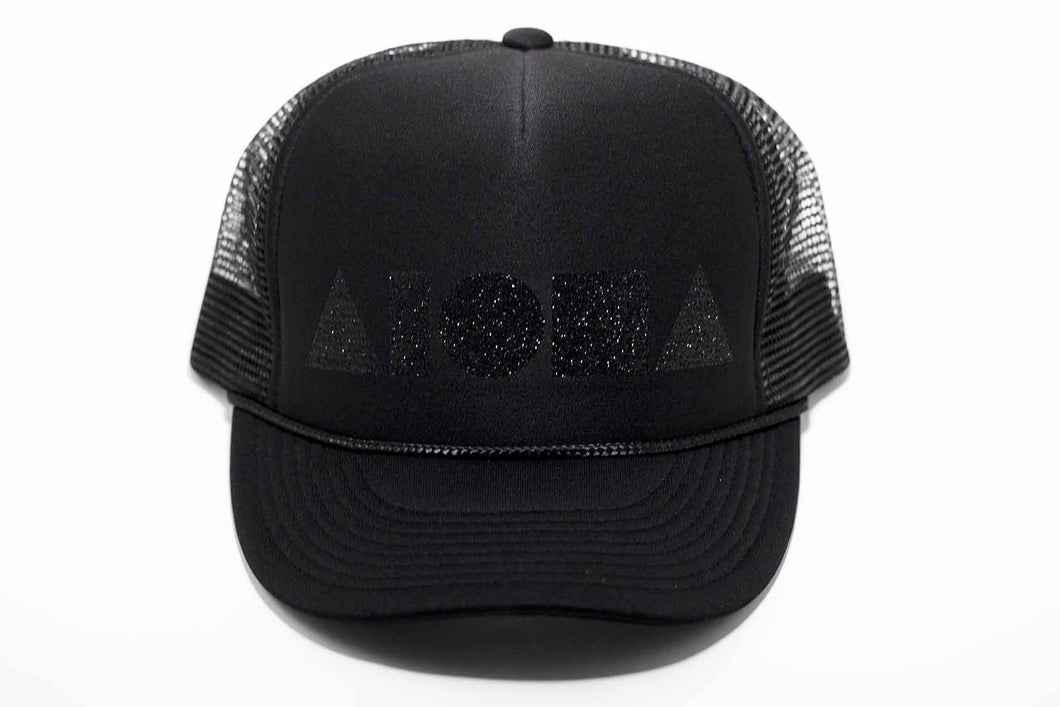 Aloha Shapes logo in black sparkles printed on an all black youth trucker hat