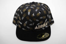 Adult flat brim snapback hat with silver and gold metallic pineapples printed on black denim. Embroidered with silver Aloha Shapes ® logo