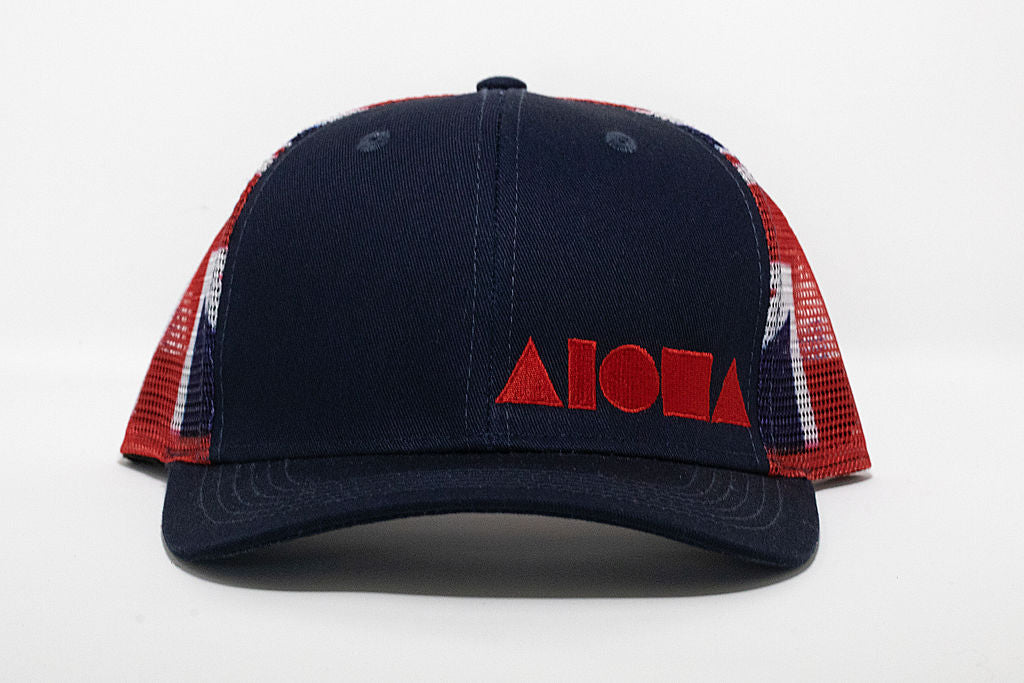 Adult curved bill snapback hat with navy blue panels on front and Hawaiian flag printed on back mesh panels. Embroidered on front with red Aloha Shapes logo
