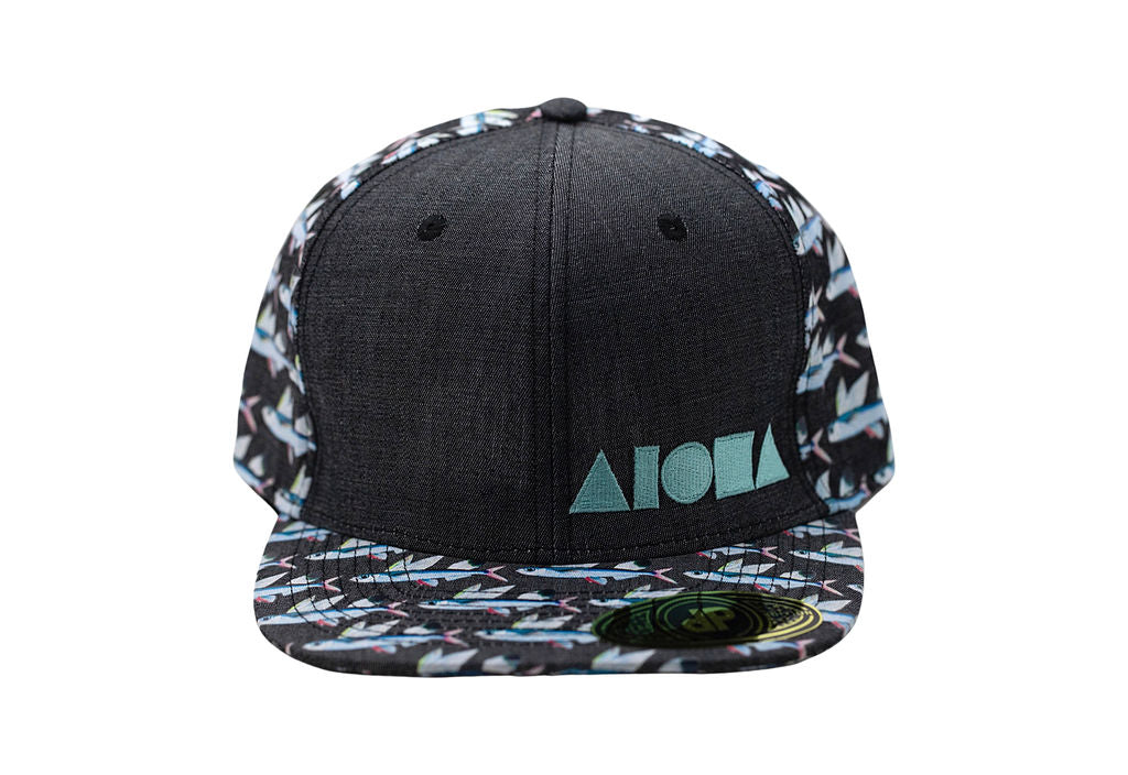 Adult flatbrim snapback hat printed with repeating pattern of flying fish. Embroidered with blue Aloha Shapes® logo