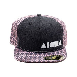 Adult flat brim snapback with black denim front panels and pink triangle pattern back panel and brim. Silver Aloha Shapes logo