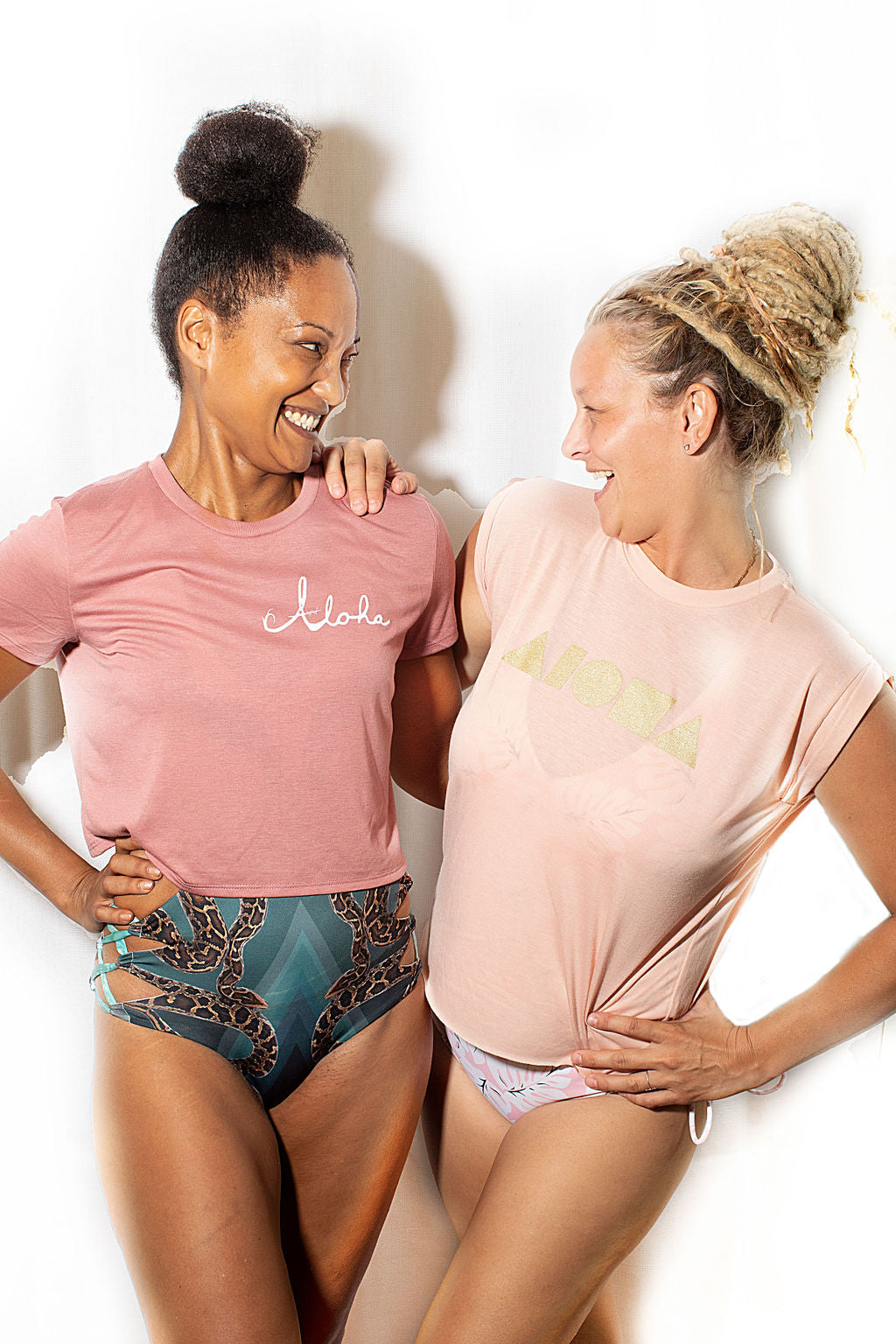Two ladies wearing Soley Aloha womens tees as swimsuit cover ups smiling at each other