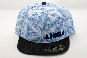 Adult flatbrim snapback hat with intertwining pattern of moi fish. Embroidered with navy blue Aloha Shapes logo