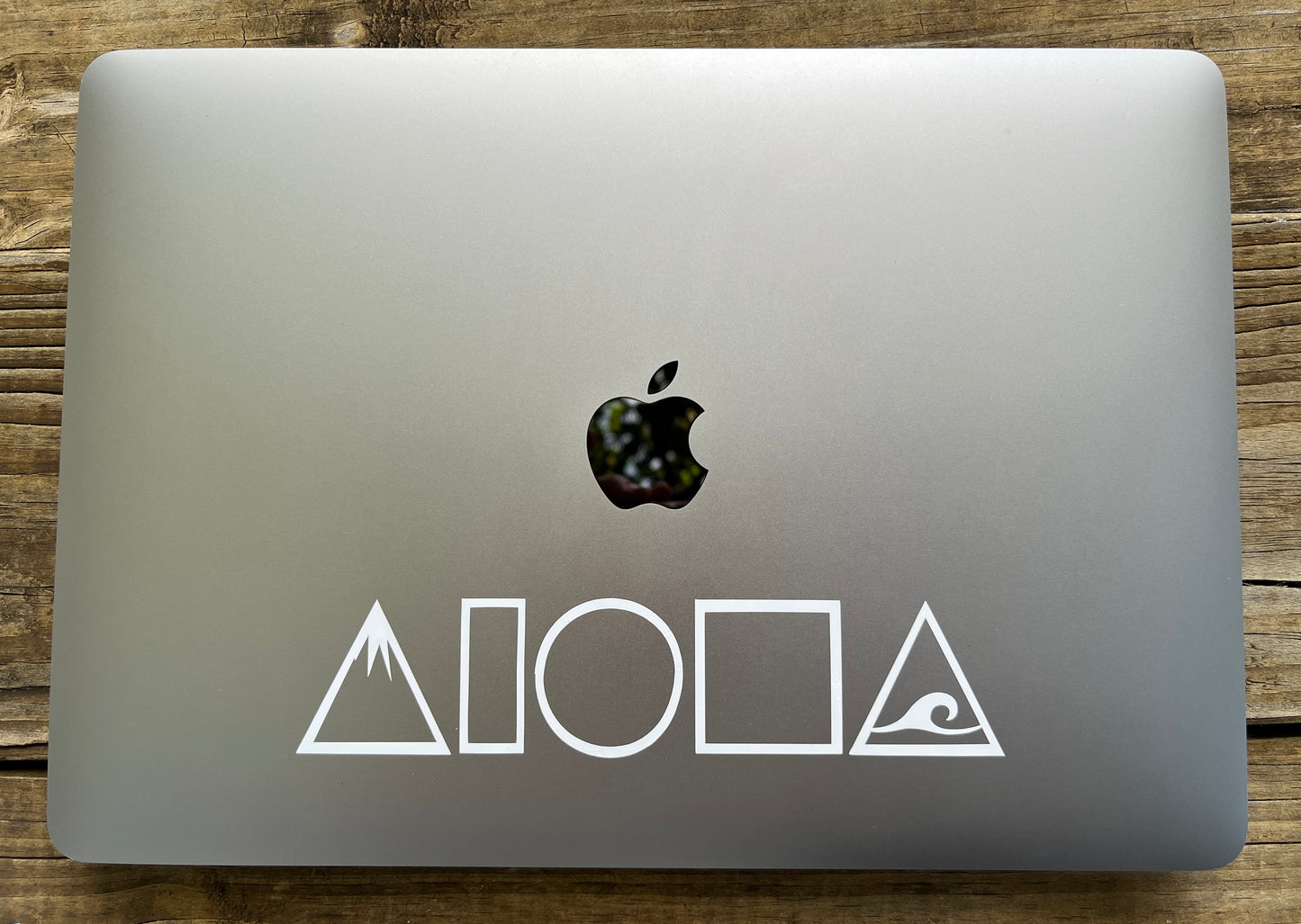 Laptop computer with a Mauka to Makai Aloha Shapes decal sticker in white stuck on the top