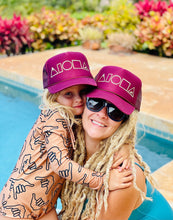 Mom and daughter wearing matching Maroon and Gold Mauka to Makai aloha shapes logo trucker hats