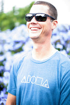Man laughing wearing our Mauka to Makai Aloha Shapes sueded jersey tee in heather deep teal
