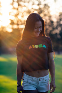 Woman in Maui wearing womens Rainbow Aloha Shapes® logo flowy crop tee
