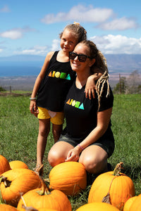 Young girl and mother in pumpkin patch in upcountry Maui Hawaii wearing black Rainbow Aloha Shapes® youth racerback tank