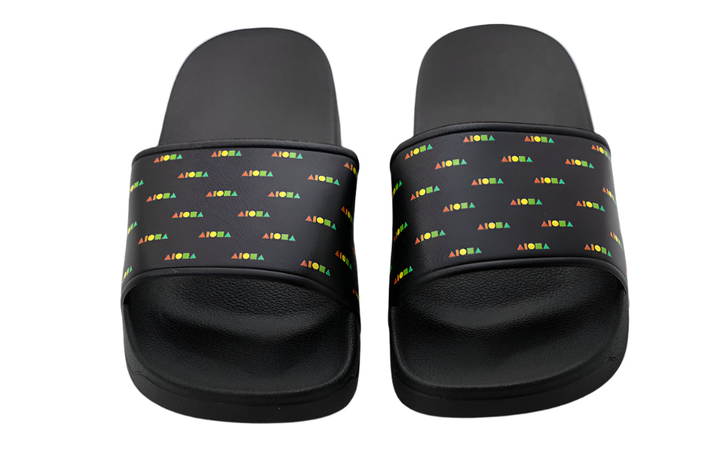 PVC slide-on slippers printed on top strap with repeating Aloha Shapes® logo in rainbow colors