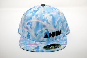 Adult flat brim snapback hat printed with rainbows and clouds. Embroidered in Maui Hawaii with black Aloha Shapes logo