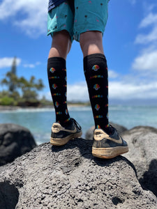 Person wearing Shave Ice Aloha Shapes® socks while looking out to the ocean