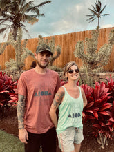 A couple wearing matching Stacked Aloha Shapes ® logo thwart and tanktop