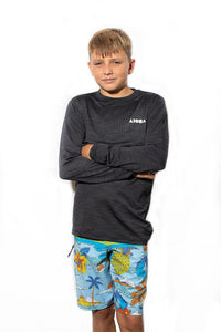 Young person wearing "Domes" Aloha Surf Shapes boardshorts and grey rashguard. 