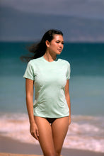 Girl with ocean behind her wearing womens short sleeve upf50 sunshirt