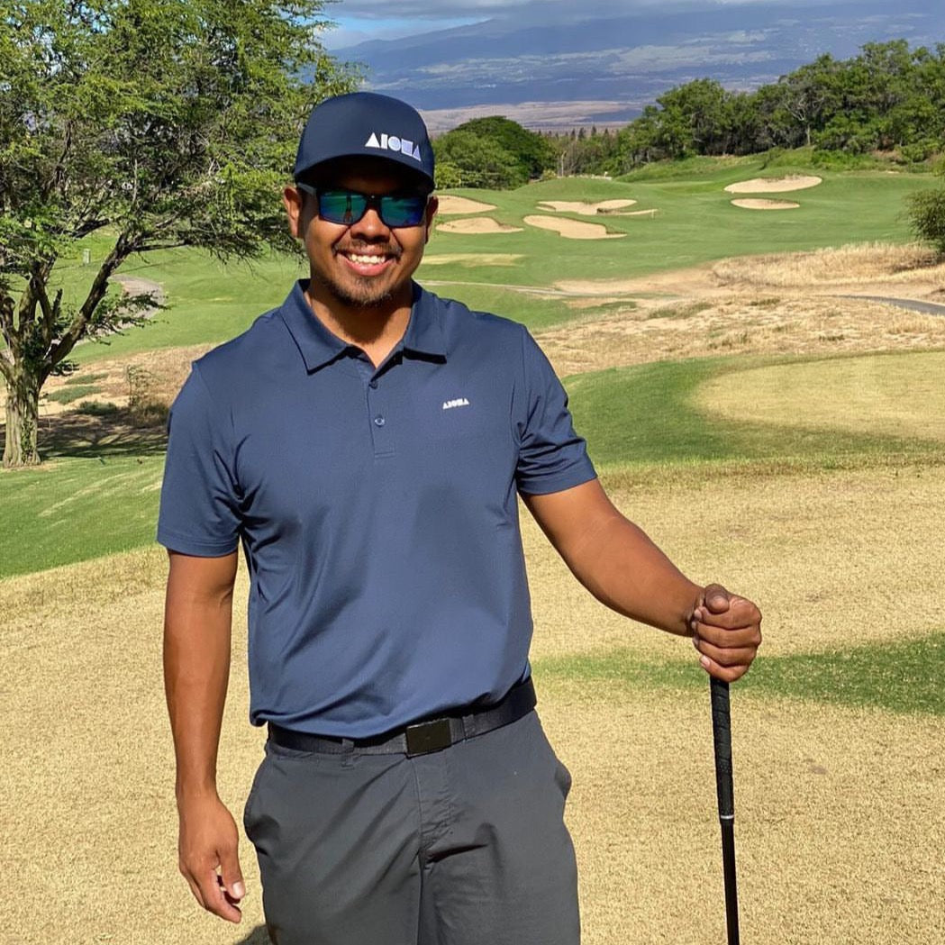 Man on golf course in Maui Hawaii wearing navy blue Aloha Shapes® flexfit cap