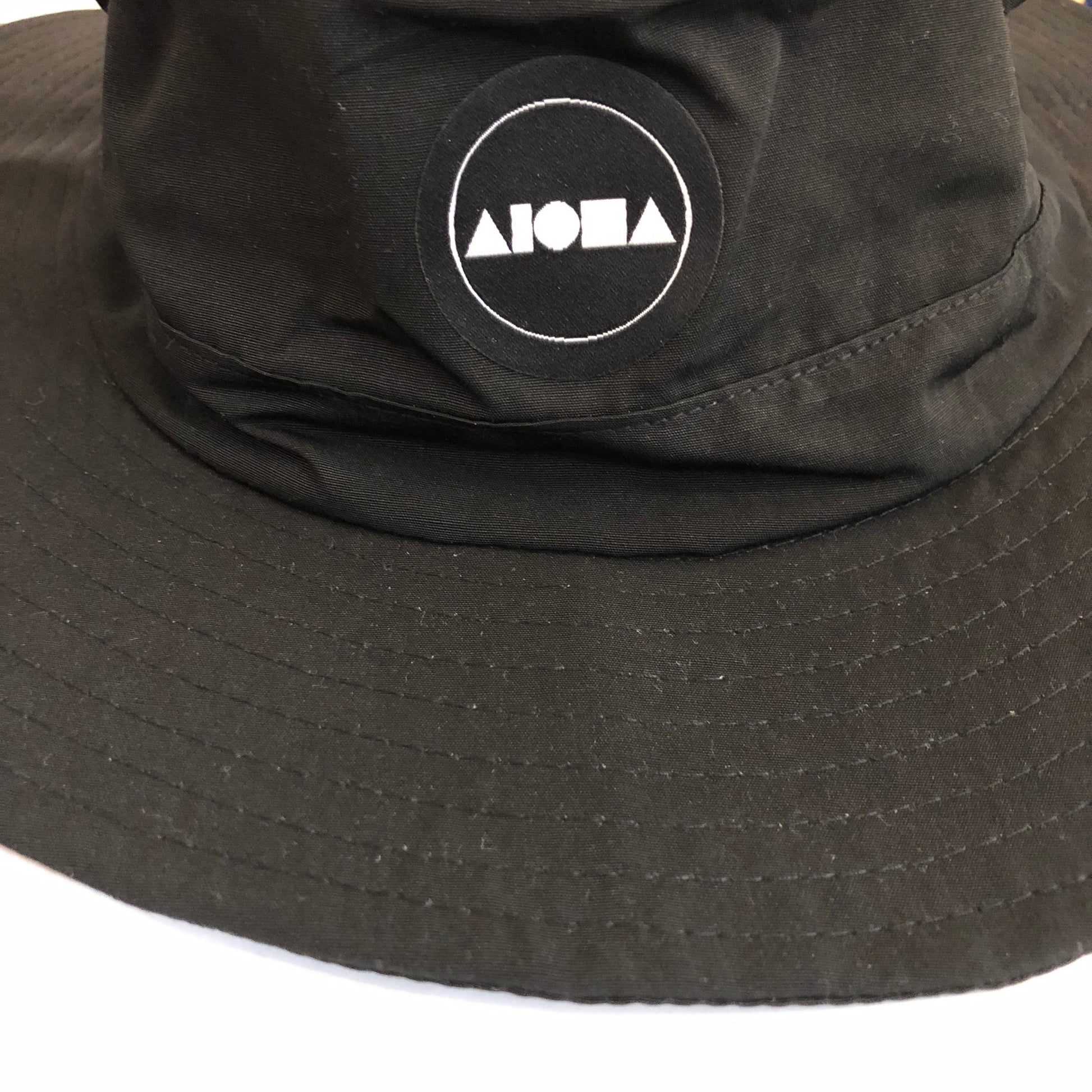 Closeup of Aloha Surf Shapes logo on black "Watson" boonie hat