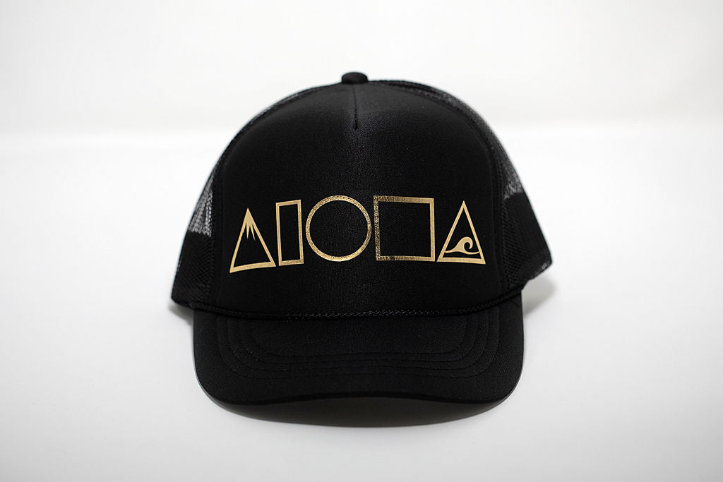 Black youth trucker hat foil printed in Maui with Mauka to Makai aloha shapes logo on front in gold