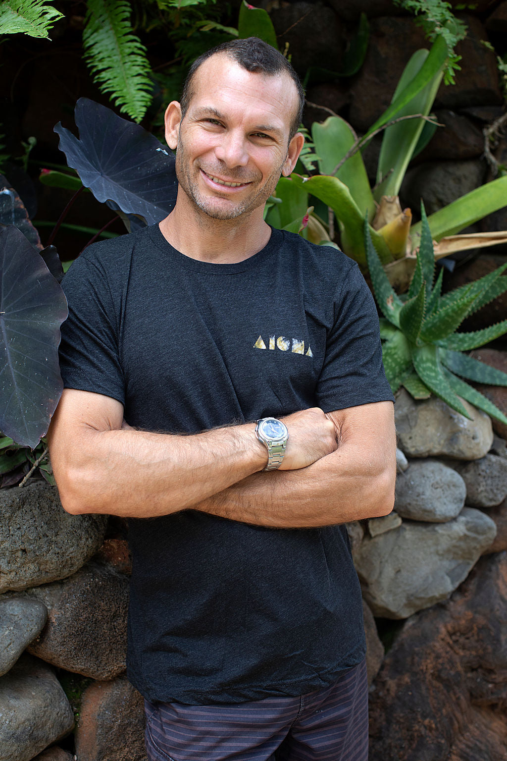Man smiling with arms crossed wearing an Aloha Shapes ® Turtle design tshirt