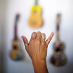 Hand throwing a Hawaiian shaka wearing assorted Wave Rings