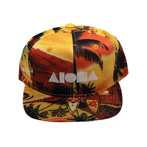 Youth flat brim snapback hat. Satin yellow tropical print. Embroidered with white ALOHA Shapes ® logo
