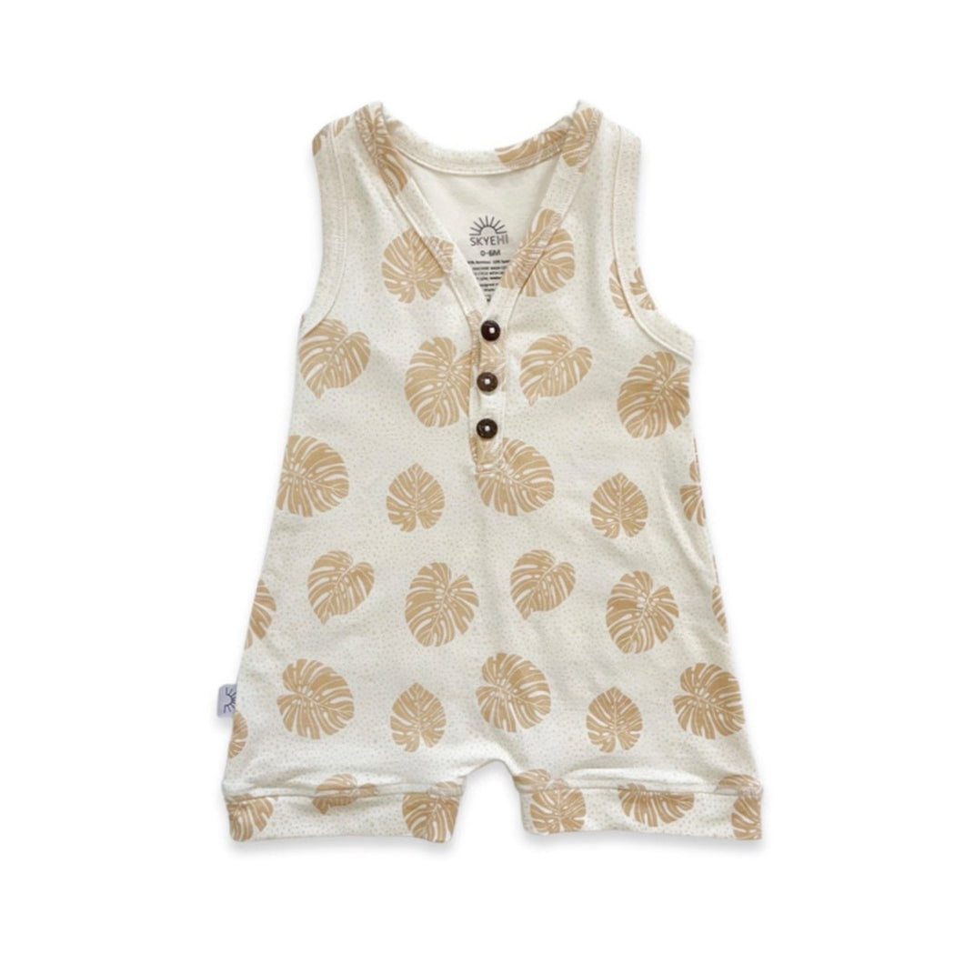 Baby/toddler romper designed in Maui Hawaii. Tan color fabric with honey brown monstera leaf print. Front view