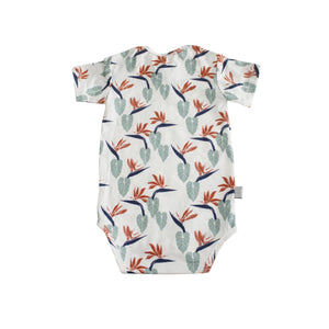 White baby onesie printed with bird of paradise designs. Designed in Hawaii. Made in Bali